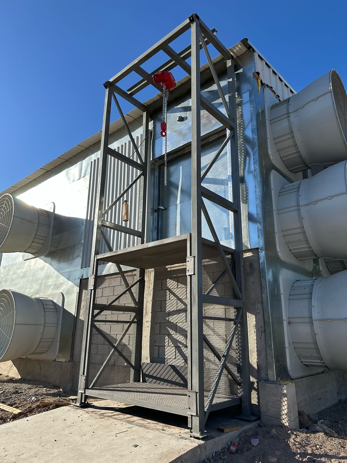 Jaula metálica y conjunto de elevación en una instalación avícola