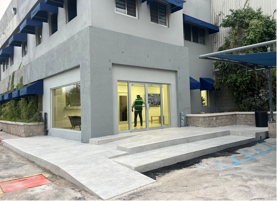 Acceso exterior terminado, con cancelería, banquetas y rampa de recepción